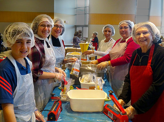 People in hairnets and aprons packing food