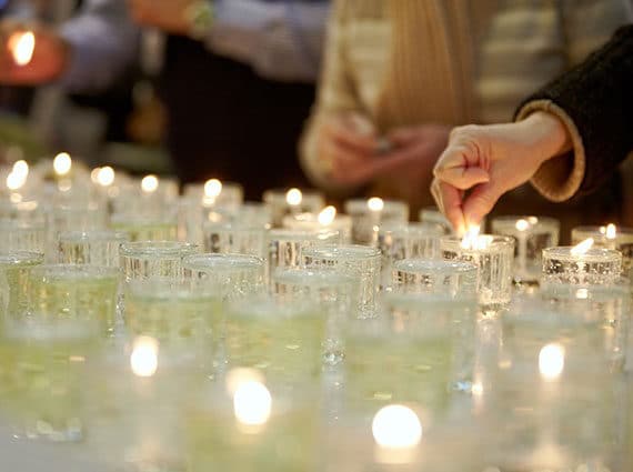 table full of votive candles in small cups