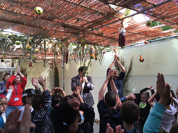 group of people having fun in a sukkah
