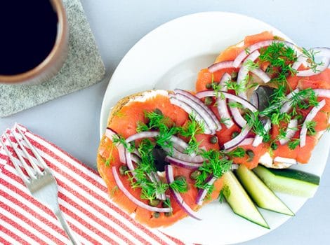bagel with lox, onion, tomato and a cup of coffee