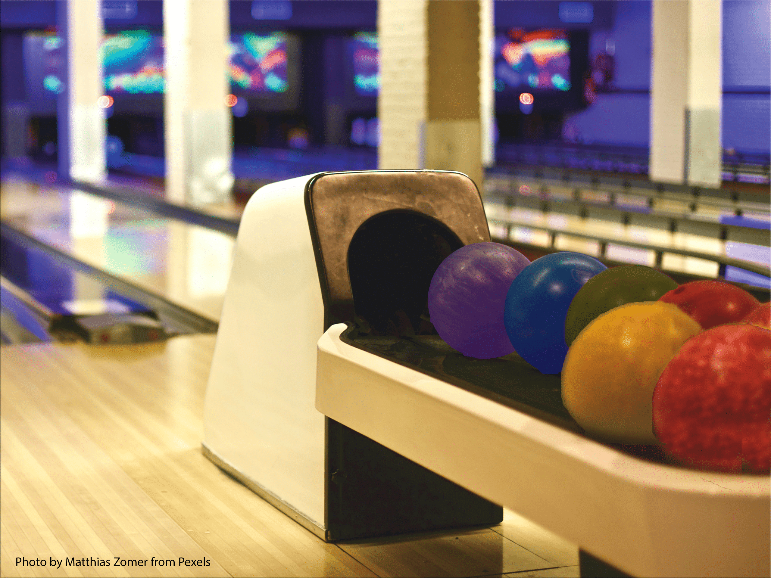 Bowling balls in rainbow colors at a bowling alley