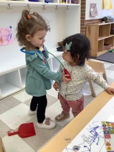 two toddlers playing with a stethoscope
