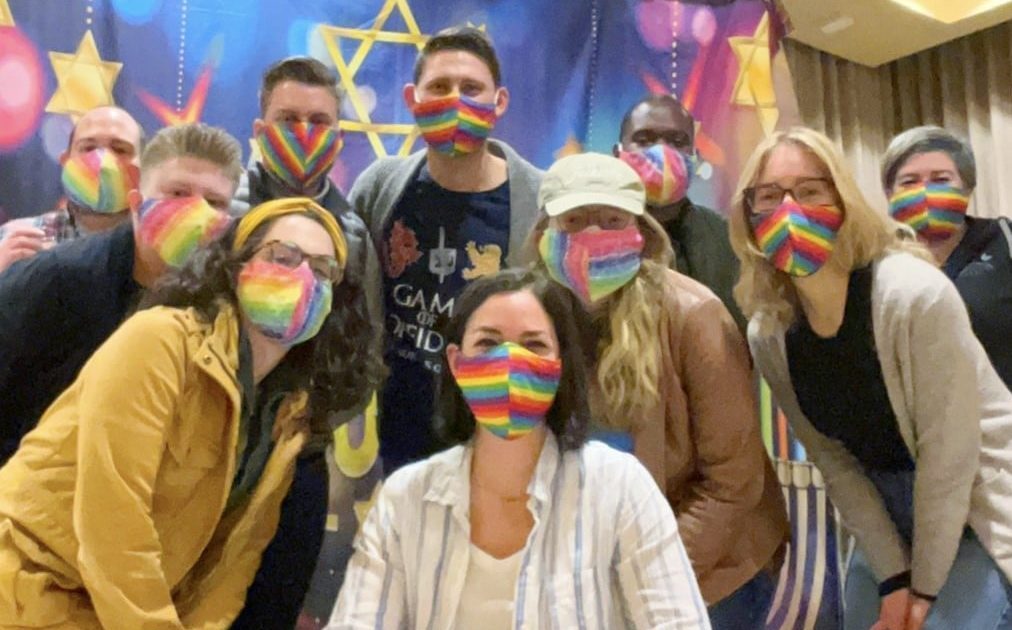 Group of people with rainbow masks on pose for the camera