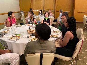 Group of Black and white people at a dinner table