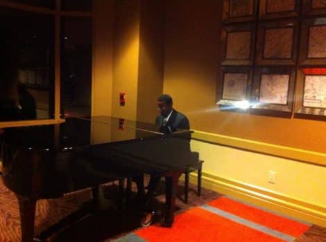 Black man playing grand piano