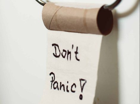 Empty toilet paper roll with onbe square that says "don't panic"