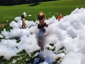 young child plays in a pile of foam