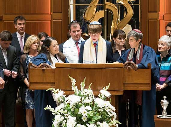 child at bima surrounded by family for bar mitzvah