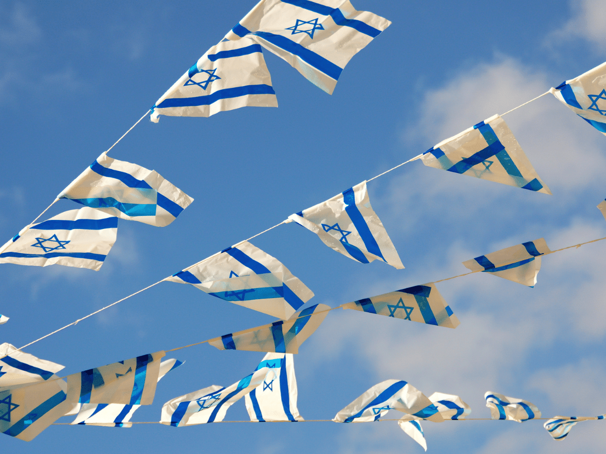 3 strings pof small Israel flags over blue sky