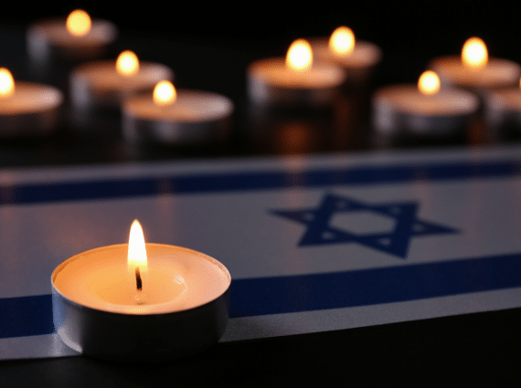 lit candles set on top of Israeli flag