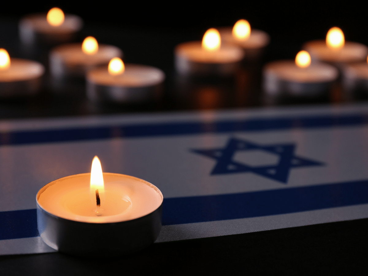 lit candles set on top of Israeli flag