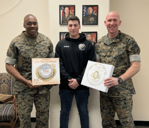 3 Marines holding up boxes of matzah