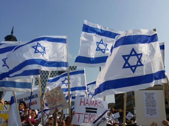 Israeli flags wave at a protest rally