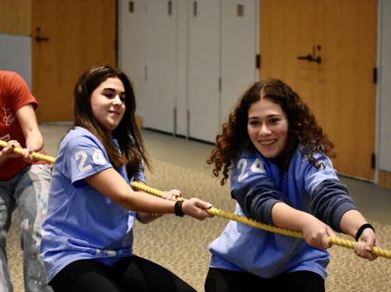 Two teen girls compete in a tug-o-war competition