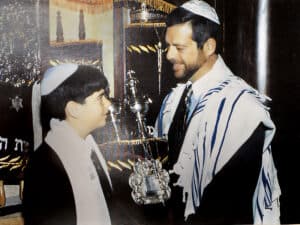 13-year-old Aaron Miller (left) receives the Torah from his father.
