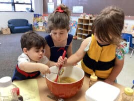 Three children around a mixing bowl