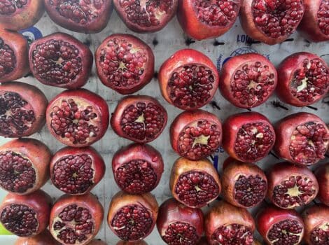 tray of pomegranate halves on display in a market
