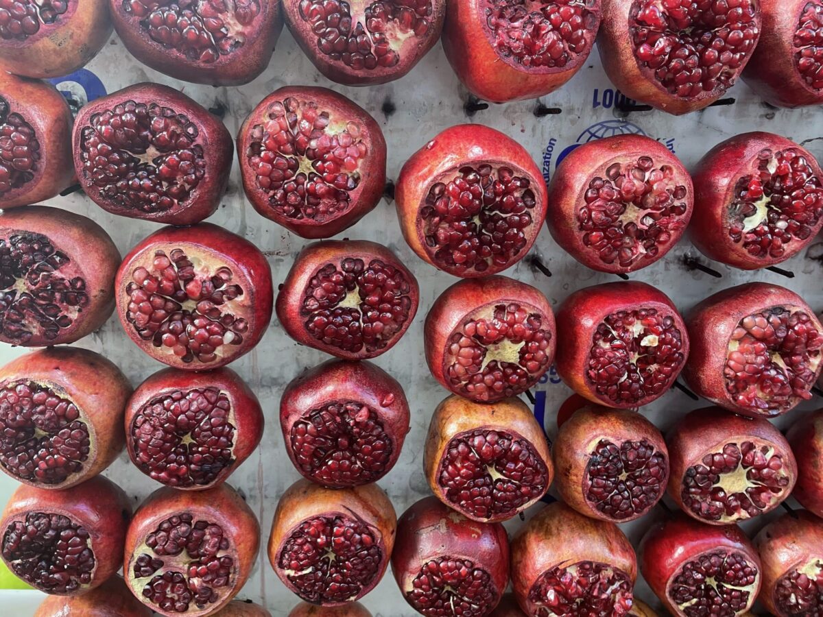 tray of pomegranate halves on display in a market