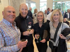 Four people standing at a cocktail party