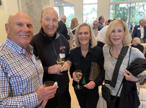 Four people standing at a cocktail party