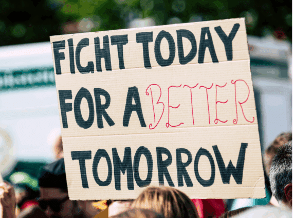 sign in a crowd of marchers saying "Fight today for a better tomorrow"