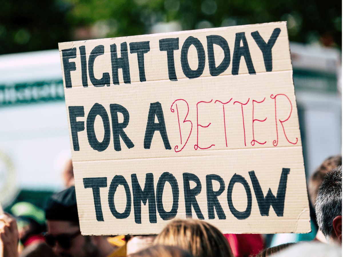 sign in a crowd of marchers saying "Fight today for a better tomorrow"