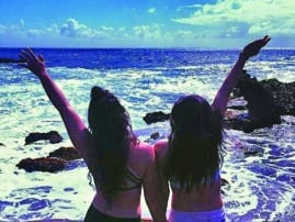 Jillian and Lindsay Wiener stand in bikinis on a beach