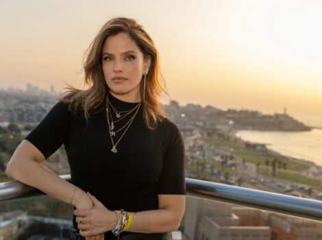 Noa Tishby stands on a balcony overlooking the ocean