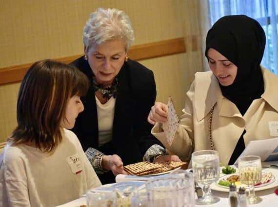 woman serves food to a woman in a hijab