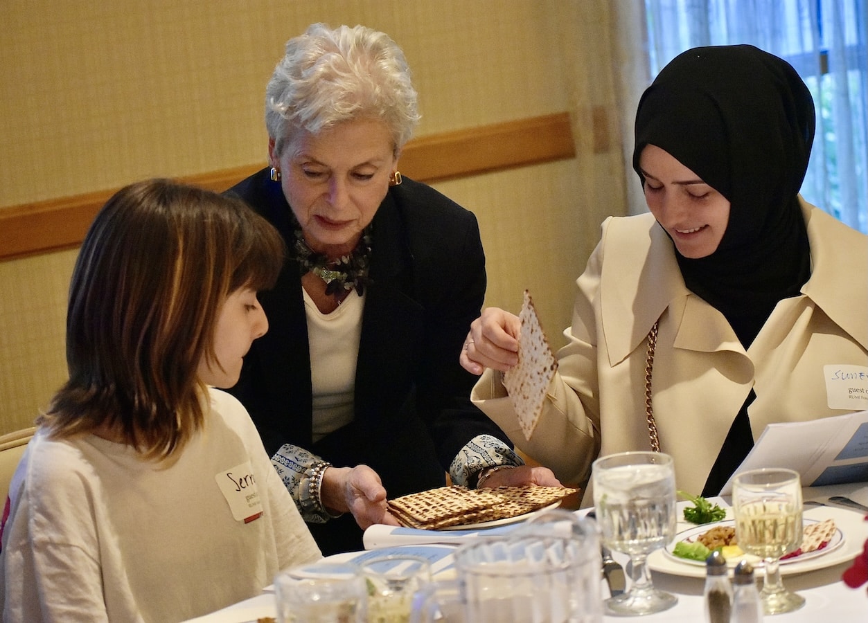 woman serves food to a woman in a hijab