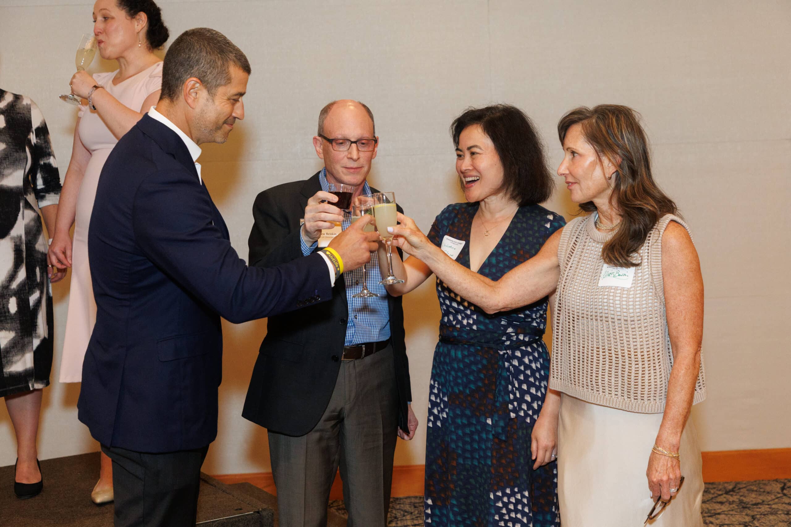 Two men and two women toast with champagne glasses