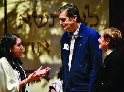 Rabbi Shankman on the bimah with a senior man and woman