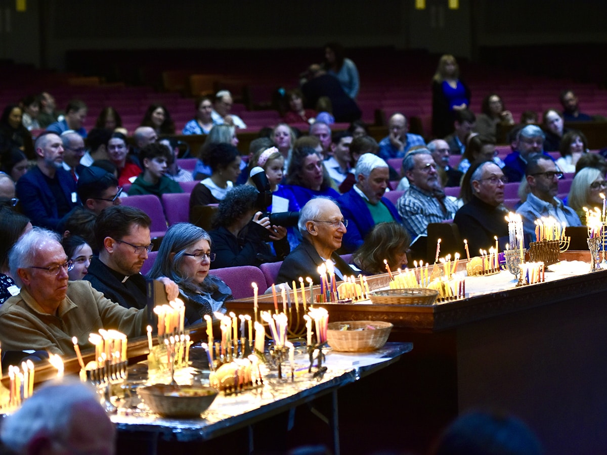 Table of lit hanukkiyot at Haunukkah Shabbat