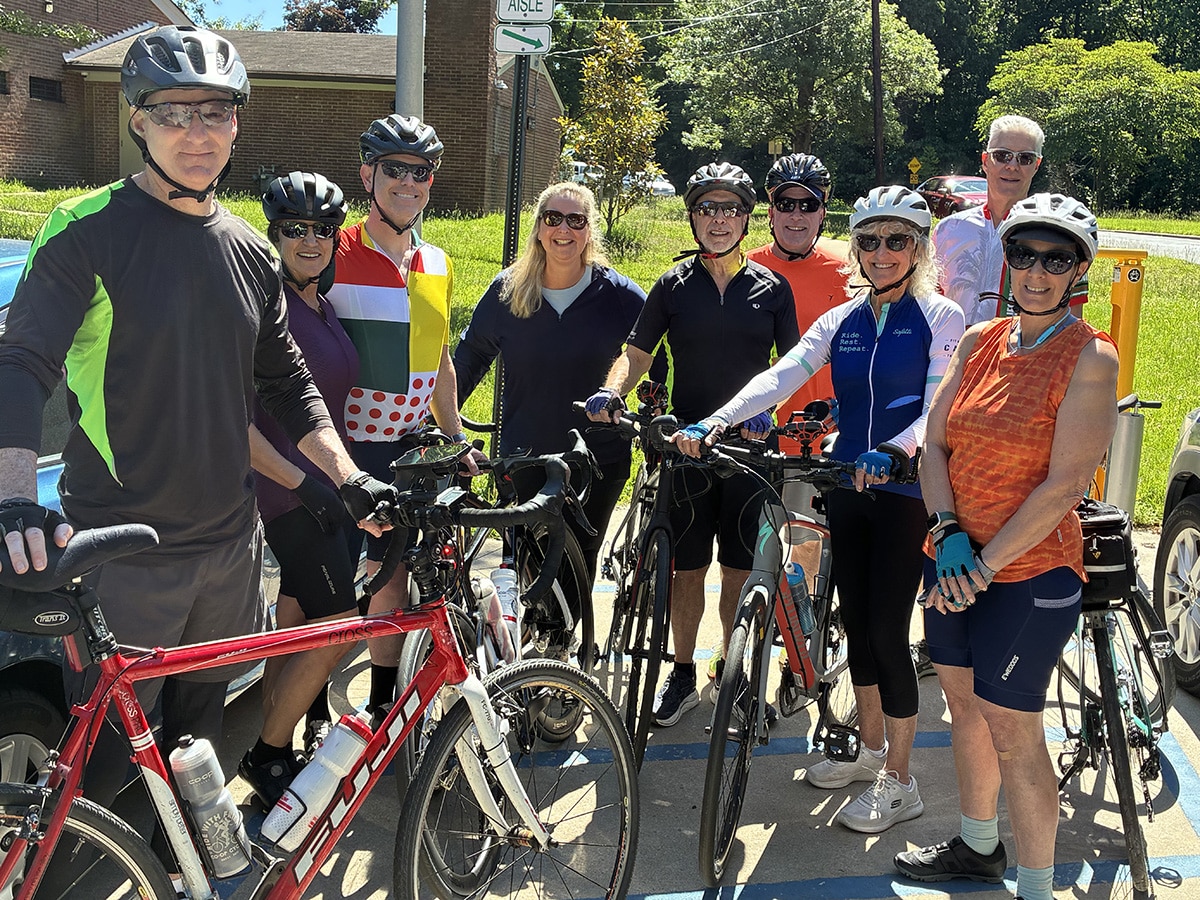 Group of people stand over their bicycles